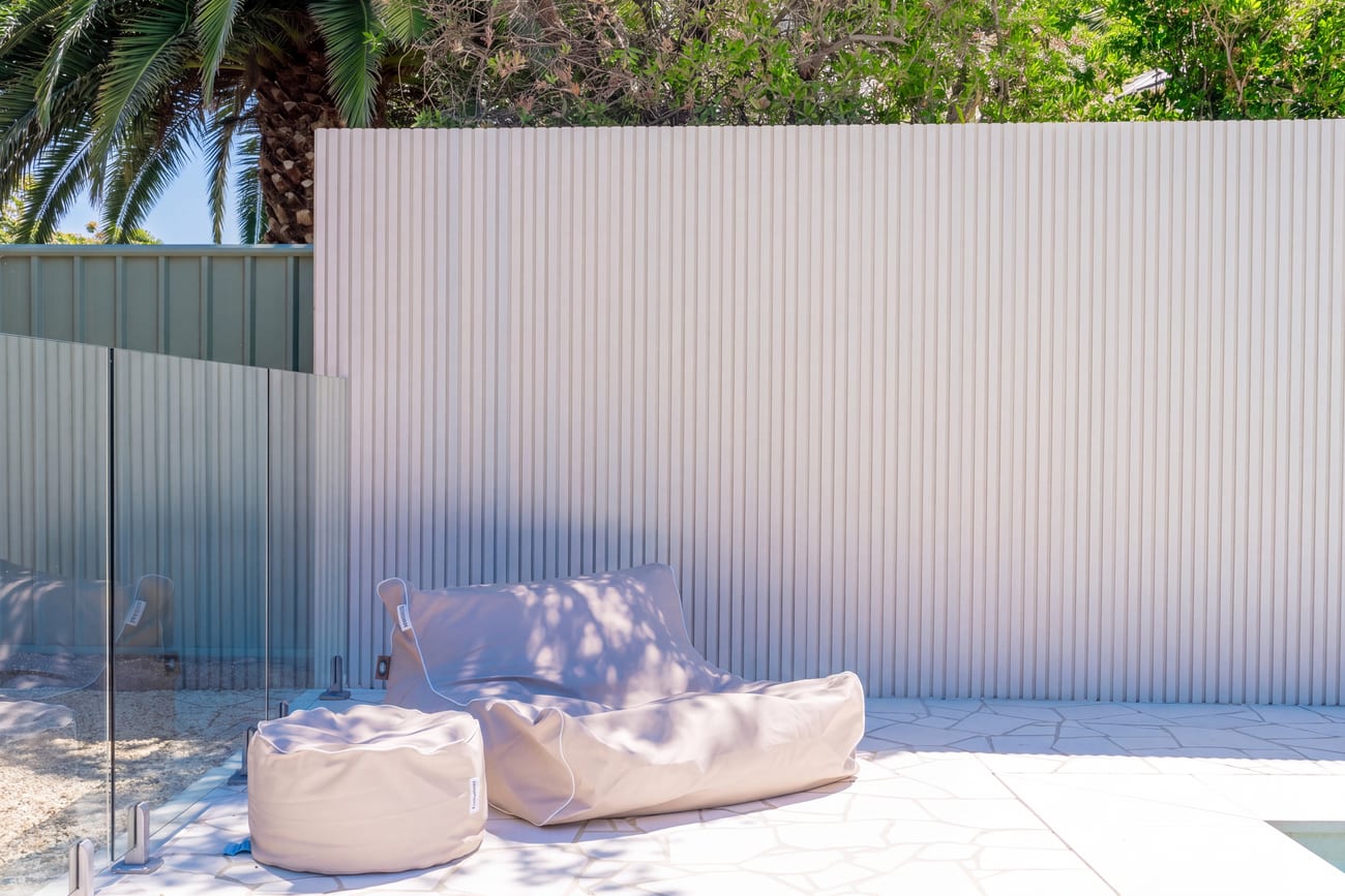 Crazy paving running to a white corrugated screen wall